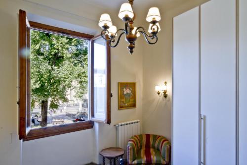 a dining room with a window and a chair at San Marco Apartment in Florence