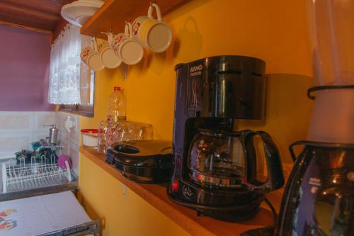a kitchen with a coffee maker on a counter at Chalés Cerejeira in Visconde De Maua
