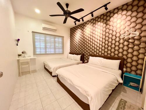 a bedroom with two beds and a ceiling fan at H&H 2 Karaoke, Ice Hockey Table, Game Console in Melaka