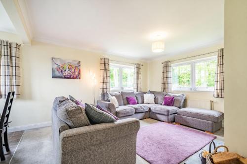 a living room with two couches and a pink rug at Falla Farmhouse in Jedburgh