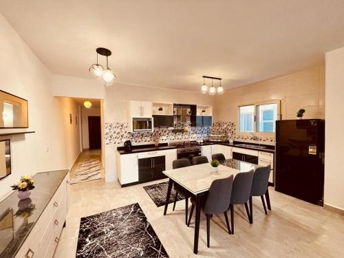 a large kitchen with a table and chairs in it at Stella Heights villa - next to Marassi - North coast in El Alamein