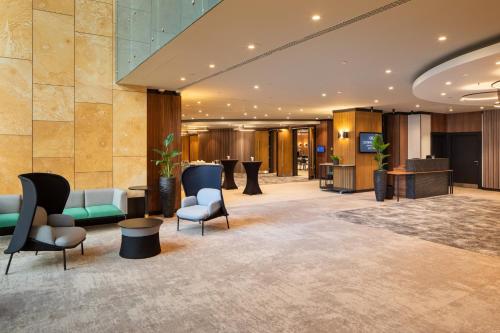 a lobby of a hotel with chairs and tables at Crowne Plaza Budapest by IHG in Budapest