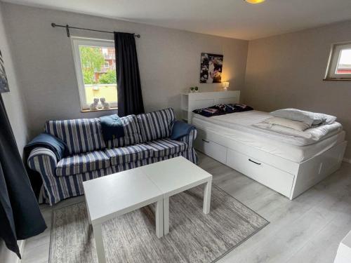 uma sala de estar com uma cama e um sofá em Holiday home ÄNGELHOLM IV em Ängelholm