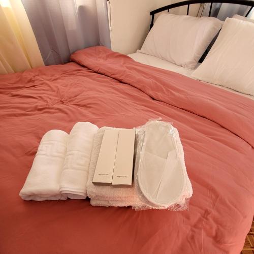 a bed with two towels and a book on it at ANDY'S PLACE in Legazpi