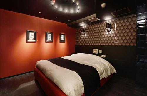 a bedroom with a large bed with red walls at Hotel LALA - Kitashiga - (Adult Only) in Nagoya