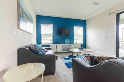 a living room with two couches and a blue wall at SPACIOUS 6bdrm Villa near ALL the attractions!! in Haines City