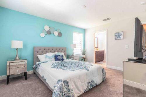 a bedroom with a bed and a blue wall at SPACIOUS 6bdrm Villa near ALL the attractions!! in Haines City