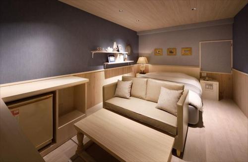 a small bedroom with a bed and a couch at Hotel LALA - Kitashiga - (Adult Only) in Nagoya