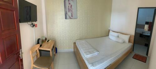a small room with a bed and a small table at Khách Sạn HOÀNG KIM in Bạc Liêu