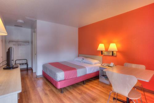 a hotel room with a bed and a desk with a phone at Motel 6-Tigard, OR - Portland South - Lake Oswego in Tigard