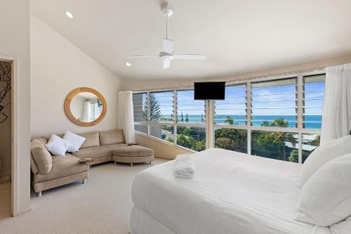 a bedroom with a bed and a couch and a large window at Unit 9 Fantastic Holiday Apartment in Sunshine Beach Stunning Views Opposite Beach Access in Sunshine Beach