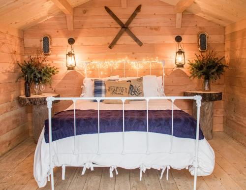 a bedroom with a white bed in a wooden wall at Between Beaches Alaska in Seldovia