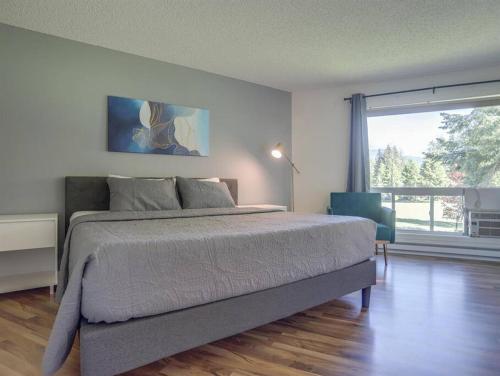 um quarto com uma cama grande e uma janela grande em SKI-Mount Hood Charm-Welches,Golf and SKI resort condo,W&D, WIFI,Near Woods,Hiking,Fishing em Mount Hood Village