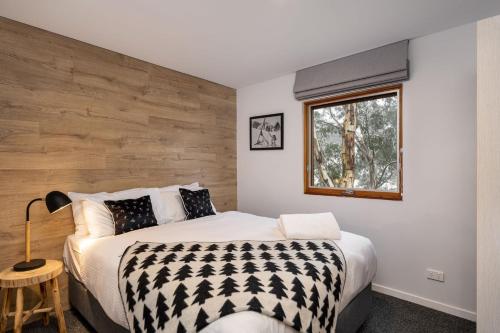 Un dormitorio con una cama grande y una ventana en Golden Eagle 2, en Thredbo