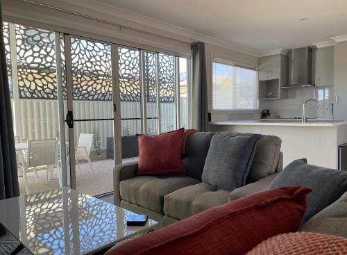 a living room with a couch and a kitchen at Apple Blossom Cottages in Stanthorpe