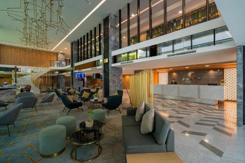 a lobby of a building with couches and chairs at Anara Airport Hotel in Tangerang