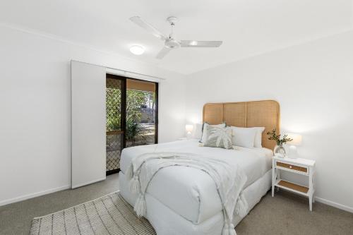 ein weißes Schlafzimmer mit einem großen Bett und einem Fenster in der Unterkunft Noosa Riverfront Splendour, Ideal for Families in Noosa Heads