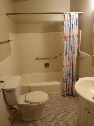 a bathroom with a toilet and a tub and a sink at Dodge Residence in Tucson