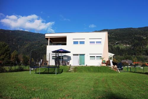 a house on a hill with a large yard at Villa Relax am See in Bodensdorf