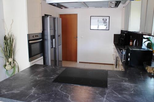 a kitchen with a black counter top and a refrigerator at Villa Relax am See in Bodensdorf