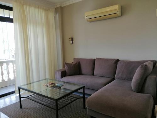 a living room with a couch and a glass table at Noble Villa Apartment in George Town