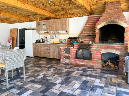 a kitchen with a brick fireplace in a room at Casa Popescu in Călimăneşti
