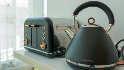 a tea kettle sitting on a counter next to a toaster at Apartament Popescu in Călimăneşti
