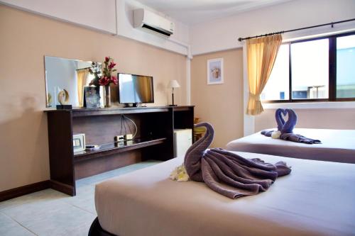 a hotel room with two beds with a swan decoration at GOLDEN GUESTHOUSE by The Beach Cha Am in Cha Am