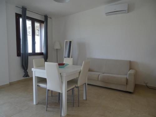 a living room with a table and chairs and a couch at Residence San Bull in Metaponto