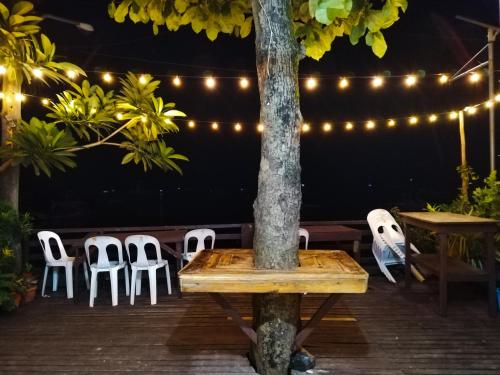 a table and chairs on a patio with lights at Joyful Guest House in El Nido