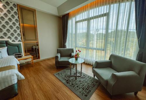a bedroom with a bed and a couch and a table at Grand Lord Hotel & Residence - Khao chi chan Pattaya in Na Jomtien