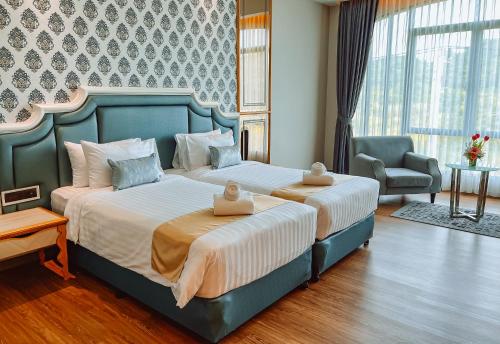 a bedroom with two beds and a chair at Grand Lord Hotel & Residence - Khao chi chan Pattaya in Na Jomtien