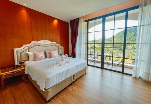 a bedroom with a bed and a large window at Grand Lord Hotel & Residence - Khao chi chan Pattaya in Na Jomtien