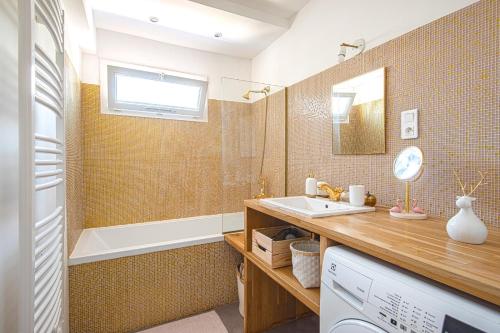 een badkamer met een wastafel en een bad bij Un balcon sur Notre Dame in Marseille