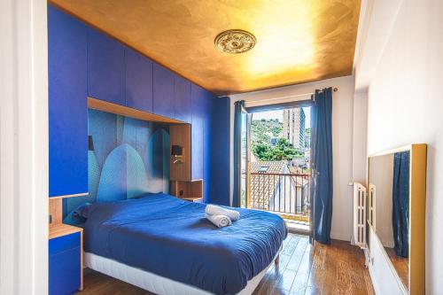 a blue bedroom with a bed and a window at Un balcon sur Notre Dame in Marseille
