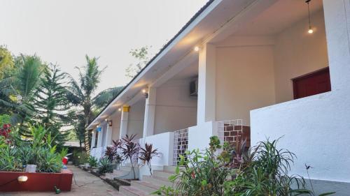 a building with stairs and plants in front of it at NomadGao Vila Nova - Comfort, Great Views, Fast WiFi & Interesting People in Anjuna