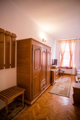 a living room with a large wooden cabinet and a television at HOTEL MARION in Dumbrăveni