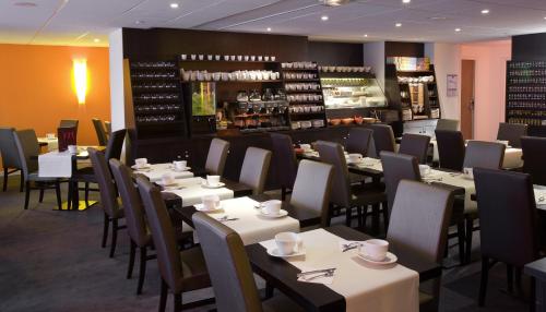 um restaurante com mesas e cadeiras e um bar em Mercure Quimper Centre em Quimper