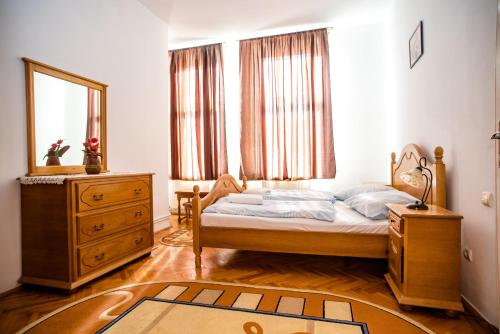 a bedroom with a bed and a dresser and a mirror at HOTEL MARION in Dumbrăveni