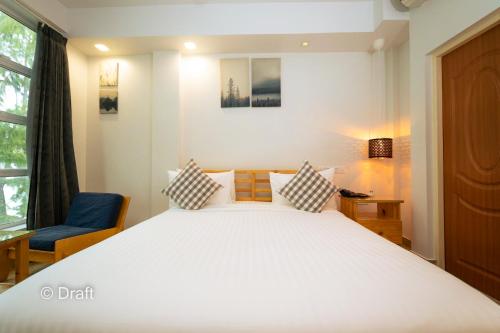 a bedroom with a large white bed and a chair at Beach Breeze and Spa in Hulhumale