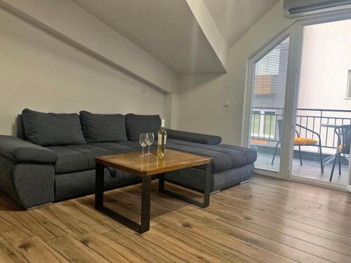 a living room with a couch and a table with wine glasses at Puro Urban in Ohrid