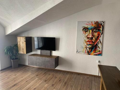 a living room with a tv and a painting on the wall at Puro Urban in Ohrid