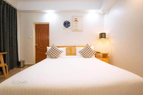 a bedroom with a large white bed with two pillows at Beach Breeze and Spa in Hulhumale