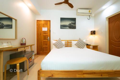 a bedroom with a bed and a desk and a television at Beach Breeze and Spa in Hulhumale