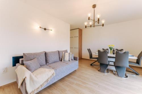 uma sala de estar com um sofá e uma mesa em Visit Baltic Apartament Łąkowa 20 em Sarbinowo