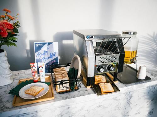 a kitchen counter with a toaster and a plate of bread at N24 Chonburi in Chon Buri