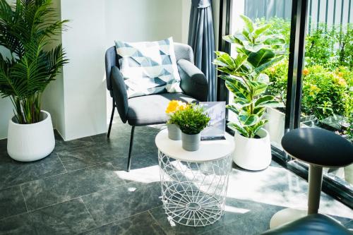 a room with a chair and a table with plants at N24 Chonburi in Chon Buri