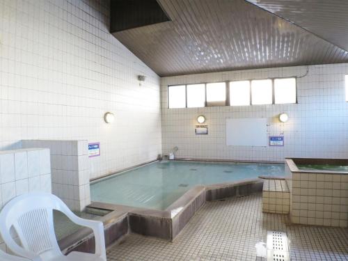 a swimming pool with a chair and a tub at ホテルスターらんど in Tsuru 