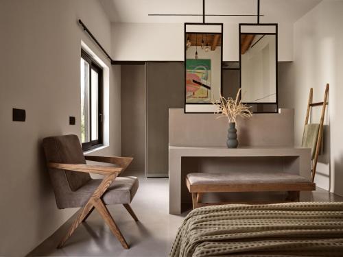 a bedroom with a chair and a desk and a mirror at Yliessa - Luxury pool villa surrounded by nature in Dhrákas