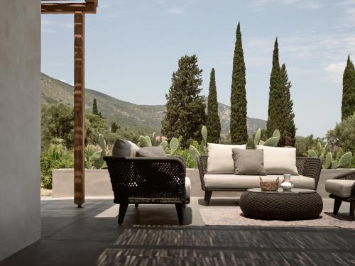 a patio with a couch and chairs and cactus at Yliessa - Luxury pool villa surrounded by nature in Dhrákas